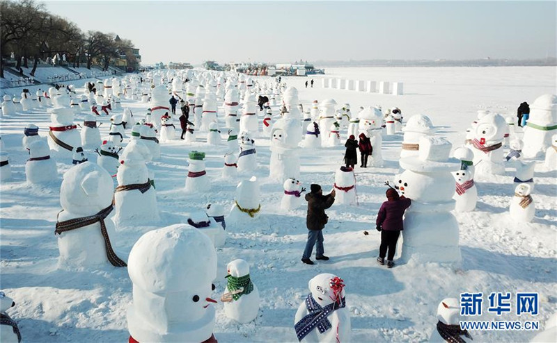 1月2日，市民、游客在雪人群中游玩觀賞（無人機拍攝）。2019個各式各樣的雪人，近日在冰城哈爾濱市的松花江畔亮相，引來眾多市民游客游玩觀賞。新華社記者 王建威 攝